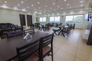 Belle Bonami Resort في فاغامون: غرفة طعام مع طاولات وكراسي ونوافذ