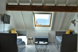 Charmant studio, le petit gris des montagnes في ماوث: غرفة صغيرة بسريرين ونافذة