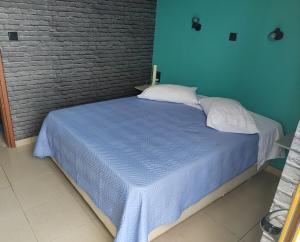 Cama en habitación con pared azul en Mandy Suites en Kíssamos