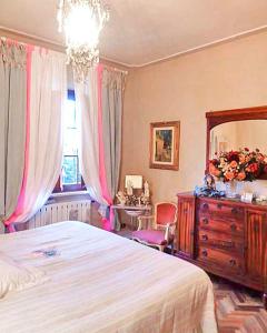een slaapkamer met een bed, een dressoir en een spiegel bij La Bouganville - Piscina e Relax in Camaiore