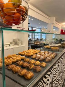 a display case in a bakery filled with lots of donuts at Hotel Vela D'Oro in Riccione