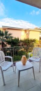 two white chairs and a table with a vase on a patio at Casa Maris in Alcamo