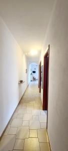 a hallway with white walls and a tile floor at Casa Maris in Alcamo