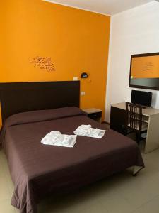 een hotelkamer met een bed met handdoeken erop bij Hotel Vela D'Oro in Riccione