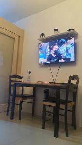 a table with a television on a wall with a table and chairs at Sea Residences EZBedz in Manila