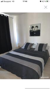 a bedroom with a large bed with black and white sheets at Le petit dieppois in Dieppe
