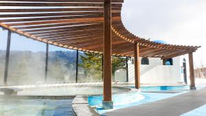 a wooden pavilion with a pool in front of a building at Phoenix Resort Pyeongchang in Pyeongchang +122 photos
