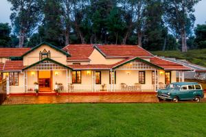 a blue car parked in front of a house at Rosewood by Nature Resorts in Ooty