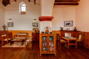a living room with wooden floors and a table and chairs at Rosewood by Nature Resorts in Ooty
