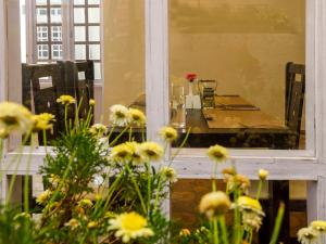 a table is seen through a window with flowers at Rosewood by Nature Resorts and Stays in Ooty