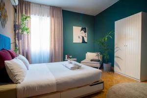 una camera con un letto bianco e una parete verde di Terzopiano a Treviso