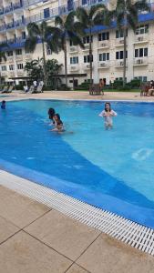 a group of children swimming in a swimming pool at Sea Residences EZBedz in Manila +39 photos