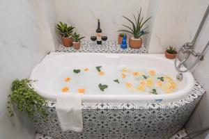 a bath tub filled with plants and flowers at C o r o n a Hanoi House in Hanoi