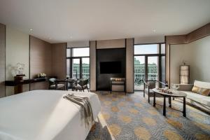 a hotel room with a bed and a living room at Beijing Hotel NUO Forbidden City in Beijing