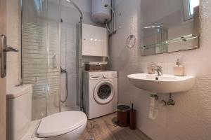 uma casa de banho com um WC, um lavatório e uma máquina de lavar roupa em Effie's Two Bedroom Apartment em Nafplio