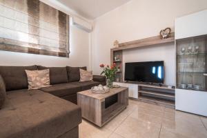 uma sala de estar com um sofá e uma televisão de ecrã plano em Effie's Two Bedroom Apartment em Nafplio