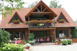 ein Haus mit einem Balkon mit Blumen darauf in der Unterkunft Cornelia Kolpak-Krieger in Pegnitz