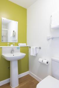 uma casa de banho com um lavatório, um espelho e um WC. em Dilkhusa Grand Hotel by Compass Hospitality em Ilfracombe
