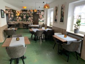 um restaurante com mesas e cadeiras e flores na parede em Garni Hotel im Fachwerkhof em Einruhr