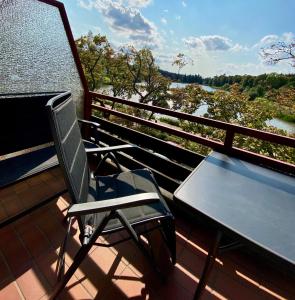 einen Stuhl und einen Tisch auf einem Balkon mit Flussblick in der Unterkunft Seeblickapp. „Eure Auszeit“ in Goslar