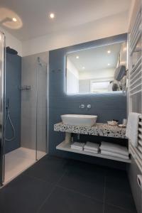 ein Bad mit einem Waschbecken und einem Spiegel in der Unterkunft Hotel Doriana in Caorle