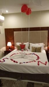 a bedroom with a bed with red flowers on it at ماسة داركم للوحدات السكنية in Buraydah