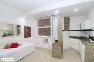 Habitación blanca con cama y cocina en Studio silencioso para 3 pessoas em Copacabana, en Río de Janeiro