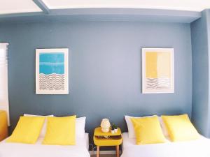 a room with a bed with yellow pillows at OUCHI HOTEL Nagarekawa with Dogs in Hiroshima