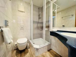 a bathroom with a shower and a toilet and a sink at Lexow - Hotel an de Havenkant in Tönning