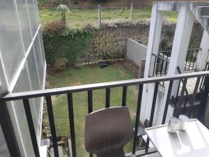 una sedia seduta sul balcone di una casa di Siril Guesthouse Hostel a Nuwara Eliya