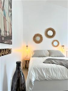 1 dormitorio con cama y espejos en la pared en Maisonnette à proximité plage et port de St-Martin en Saint-Martin-de-Ré
