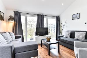 a living room with a couch and a tv at Bermondsey Central London Apartments in London
