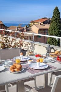 a table with plates of food on a balcony at LA ROCCA SUITE in Garda