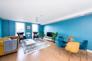 a living room with blue walls and a couch and chairs at 48 Annandale Street in Edinburgh