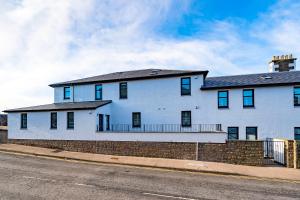 a white house on the side of a street at W. Queen St. Apt. in Broughty Ferry