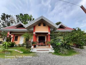 uma casa com um vermelho e amarelo em Coco Grove Pension and Beach Resort em Sindangan