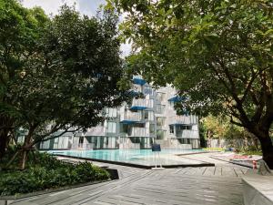 a building with a swimming pool next to trees at The Deck Patong studio 155 by AM in Patong Beach