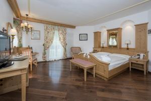 a living room filled with furniture and a large window at Hotel B&B Andreas in Canazei