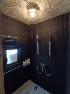 ein Bad mit einer Dusche mit Deckenbeleuchtung in der Unterkunft Camellia 2022 in Jiufen