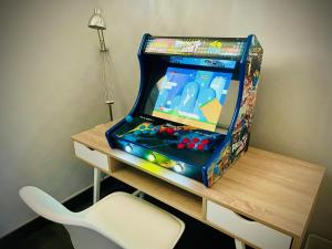 uma máquina de jogos de vídeo sentada numa secretária em Villa 200m2 avec PISCINE chauffée & SPA & sauna & kota-grill em Laval-sur-Vologne