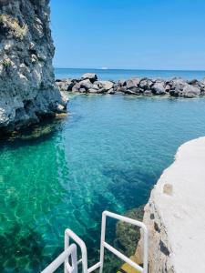 a pool of blue water next to a rocky beach at Pagoda Lifestyle Hotel in Ischia