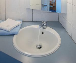 a white sink in a bathroom with a mirror at Pension Huttental in Bad Soden-Salmünster +7 photos
