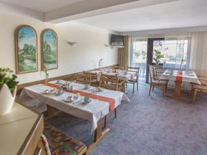 a dining room with tables and chairs and windows at Pension Huttental in Bad Soden-Salmünster
