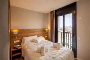 een slaapkamer met een bed en een groot raam bij Tgna Rambla 68 in Tarragona