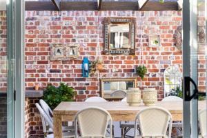 a dining room with a brick wall and a table and chairs at Ryze N Shine - Dunsborough in Dunsborough