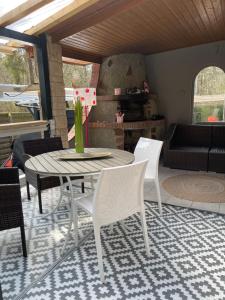 eine Terrasse mit Tisch und Stühlen auf einem Teppich in der Unterkunft Bungalow 300 Meter vom Grünewald Lauch in Staupitz