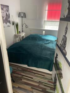 ein Schlafzimmer mit einem Bett mit einer grünen Decke in der Unterkunft Bungalow 300 Meter vom Grünewald Lauch in Staupitz