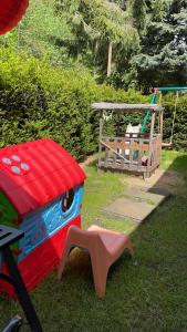 einen Spielplatz mit Spielhaus und Schaukel in der Unterkunft Bungalow 300 Meter vom Grünewald Lauch in Staupitz