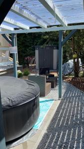 eine Pergola mit einem Bett und einer Couch darunter in der Unterkunft Bungalow 300 Meter vom Grünewald Lauch in Staupitz