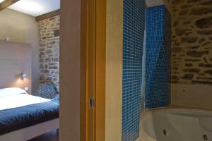 a bathroom with a bed and a window at Posada Real de Las Misas in Puebla de Sanabria